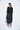 Woman wearing a black dress with a white background