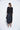 Woman wearing a black dress with a white background