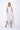 A woman wearing a light grey sleeveless knee-length dress with pockets in a white background setting.