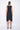 Black sleeveless dress worn by a person on a white background