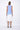 A sleeveless, hand-dyed dress with ombre coloring, transitioning from blue at the top to white at the bottom, worn by a model posing against a white background.