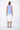 A sleeveless, hand-dyed dress with ombre coloring, transitioning from blue at the top to white at the bottom, worn by a model posing against a white background.