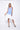 A female model wearing a sleeveless, hand-dyed blue and white knee-length dress with side seam pockets, asymmetrical hem and a racerback design.