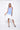 A female model wearing a sleeveless, hand-dyed blue and white knee-length dress with side seam pockets, asymmetrical hem and a racerback design.