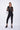Woman wearing a black outfit with sheer sleeves on a white background
