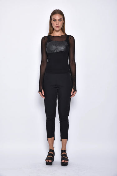 Woman wearing a black outfit with sheer sleeves on a white background