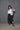 A model wearing a white boxy shirt with black strokes and black culotte pants.