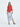 A female model wearing a Red sleeveless top, uneven hem, Black horizontal striped asymmetrical skirt and sandals against a white background
