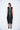 Woman wearing a black sleeveless dress on a white background