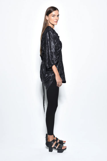 Woman wearing a black metallic outfit on a white background