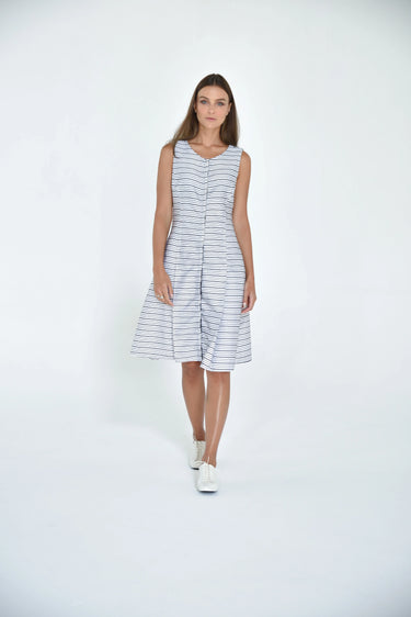 A female model wearing a sleeveless knee-length dress with horizontal black stripes and round neckline, standing against a white background.