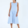 Woman wearing a light blue dress with oversized pockets on a white background