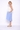 Woman wearing a white top and light blue skirt on a white background