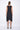 Black sleeveless dress worn by a person on a white background