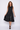 Woman wearing a black sleeveless dress on a white background