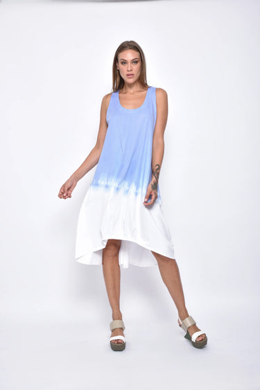 A female model wearing a sleeveless, hand-dyed blue and white knee-length dress with side seam pockets, asymmetrical hem and a racerback design.
