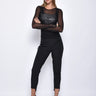 Woman wearing a black outfit with sheer sleeves on a white background
