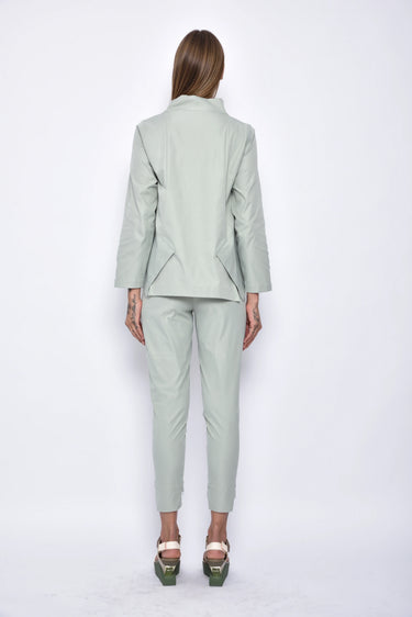 Person wearing a light green suit on a white background