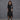 Person wearing a black outfit with a textured background