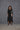 Person wearing a black outfit with a textured background