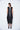 Woman wearing a black sleeveless dress on a white background