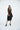 Woman wearing a black sleeveless dress on a white background